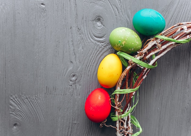 Oeufs de Pâques et une couronne sur un fond en bois