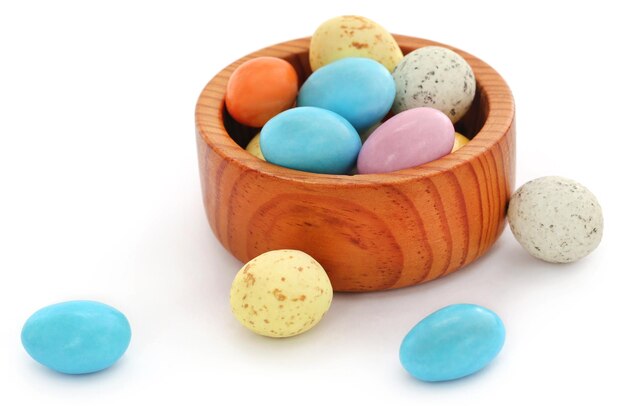 Oeufs de Pâques dans un bol en bois sur fond blanc