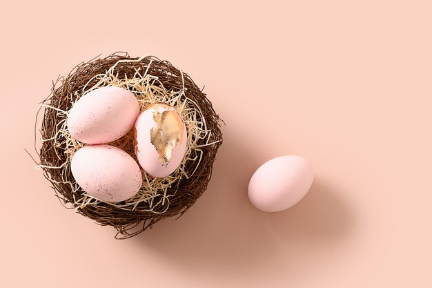 Oeufs de Pâques dans le nid sur fond rose