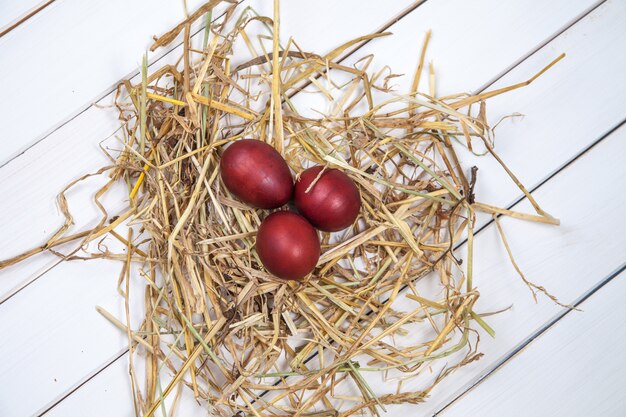 Oeufs de Pâques dans un nid de paille sur fond de bois rustique. Joyeuses Pâques!