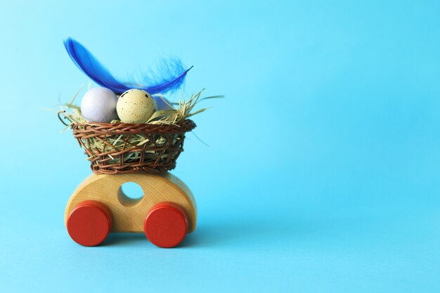 Oeufs de Pâques dans un panier, décorations et lièvres sur petites voitures, félicitations, carte postale