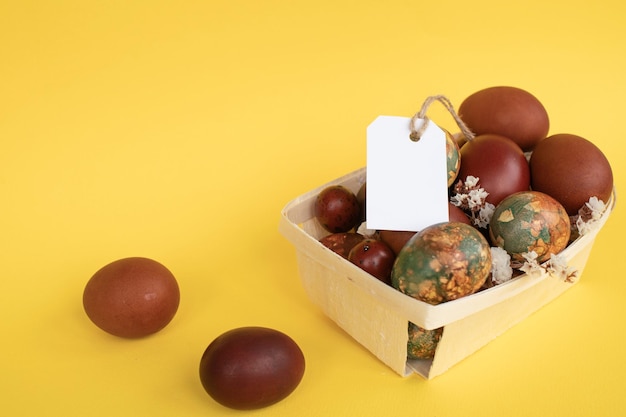 Des œufs de Pâques dans un panier avec une étiquette