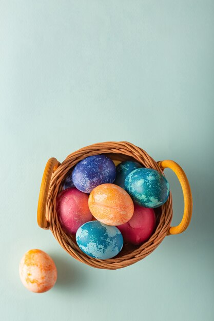 Oeufs de Pâques dans un panier sur fond bleu