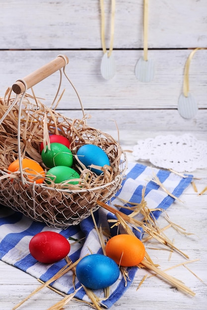 Oeufs de Pâques dans le panier sur fond de planches de bois vintage