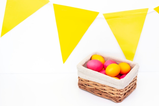 Oeufs de Pâques dans le panier. Joyeuses Pâques. oeufs peints sur une surface claire