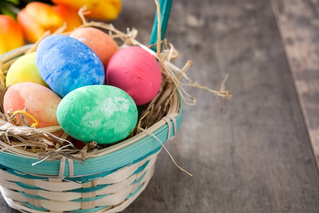 Oeufs de Pâques dans un panier et tulipes