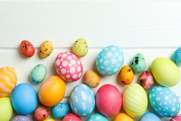 Oeufs de Pâques décoratifs sur fond de bois blanc