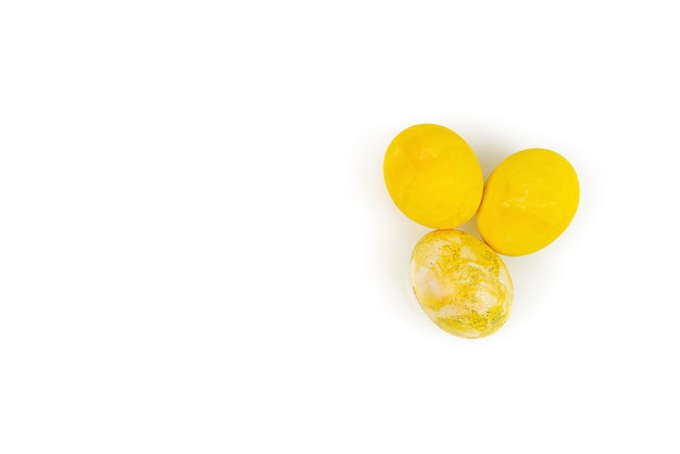 Oeufs de Pâques décorés jaunes isolés sur une surface blanche