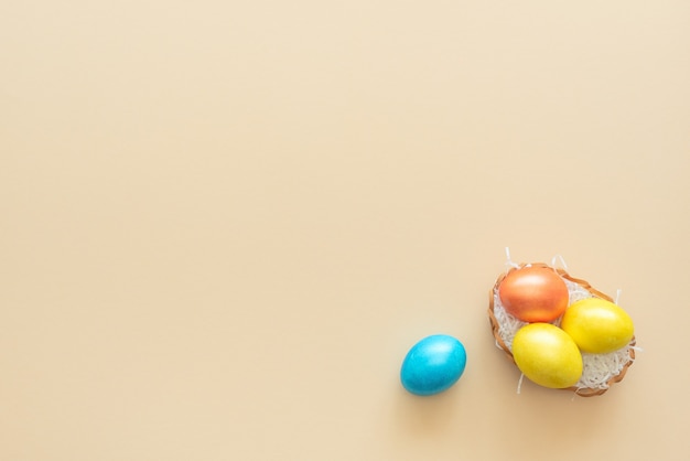 Les oeufs de Pâques décorés se trouvent dans le panier comme un nid sur jaune