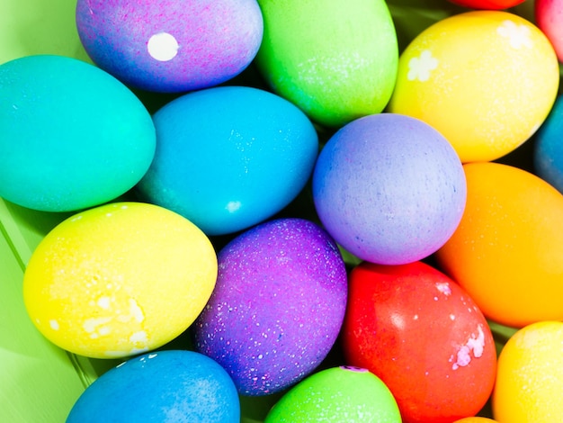 Oeufs de Pâques décorés sur table verte.