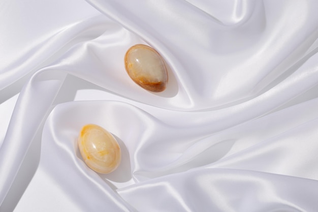 Oeufs de Pâques fabriqués à partir d'onyx de pierres précieuses naturelles sur un tissu blanc Printemps tendance Mise à plat minimale