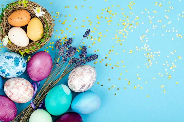 Oeufs de Pâques faits à la main décorés pour la période des fêtes sur fond bleu. Concept abstrait minimal créatif. Photo studio