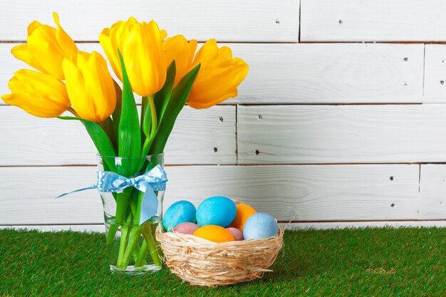 Oeufs de Pâques avec fleur sur l'herbe verte