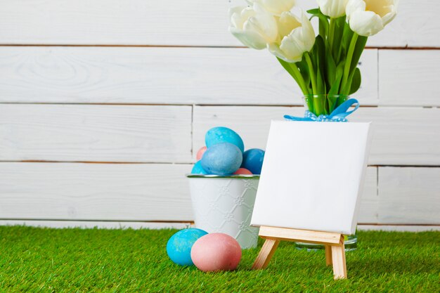 Oeufs de Pâques avec fleur sur l'herbe verte