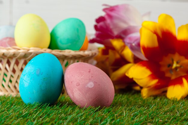 Oeufs de Pâques avec fleur sur l'herbe verte