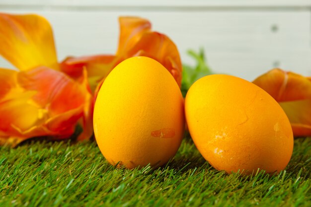 Oeufs de Pâques avec des fleurs sur l'herbe verte