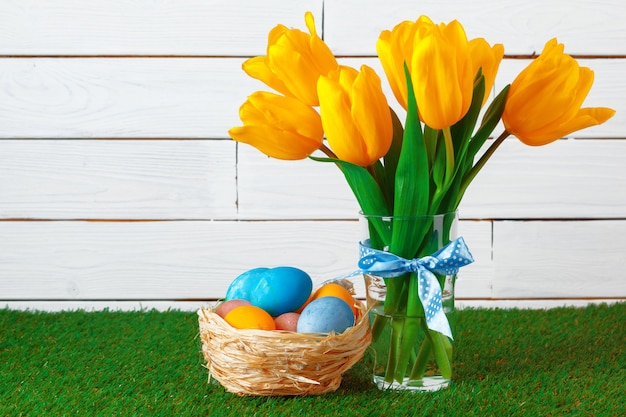 Oeufs de Pâques avec des fleurs sur l'herbe verte