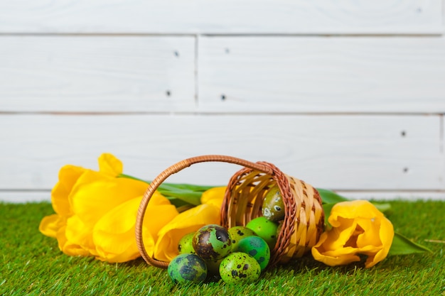 Oeufs de Pâques avec des fleurs sur l'herbe verte