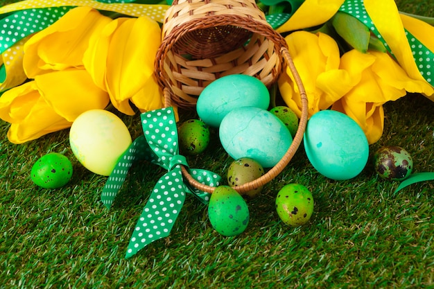 Oeufs de Pâques avec des fleurs sur l'herbe verte