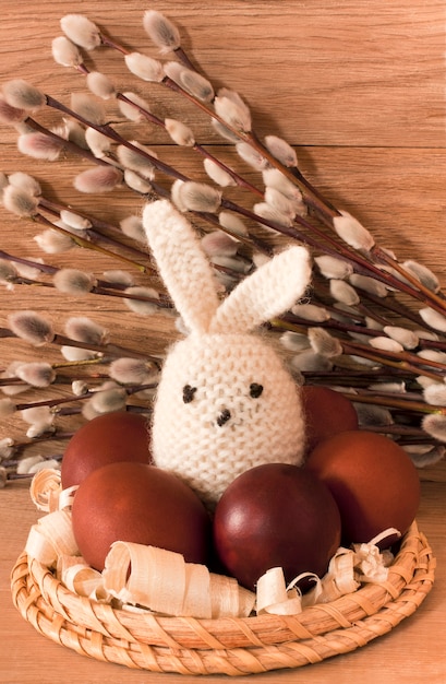 Oeufs de Pâques, lapin et chatons sur un fond en bois