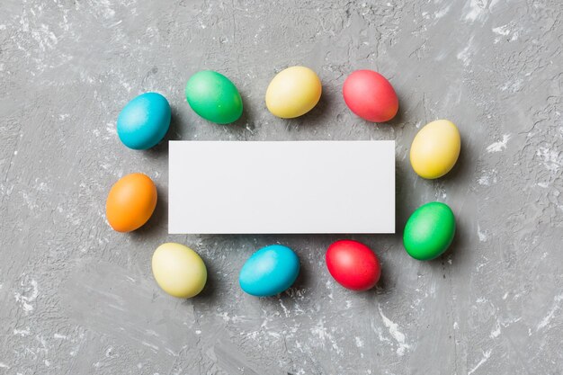 Oeufs de Pâques multicolores à cadre rond avec du papier blanc vierge sur un fond marron espace libre pour le texte vierge pour la conception image teintée de mise au point sélective
