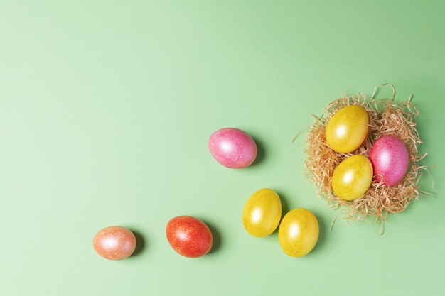 Oeufs de Pâques multicolores peints se trouve dans un nid en paille