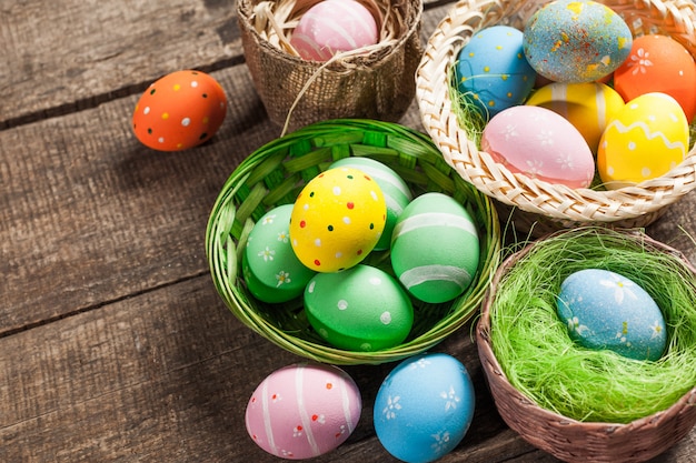 Oeufs de Pâques en nid sur fond en bois de couleur