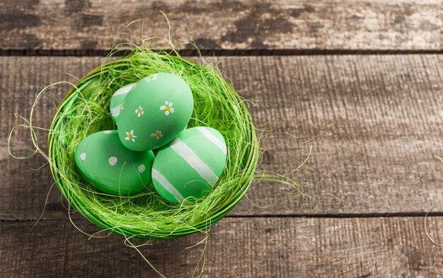 Oeufs de Pâques en nid sur fond en bois de couleur