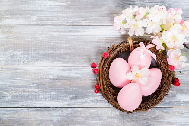 Photo oeufs de pâques en nid sur mur en bois