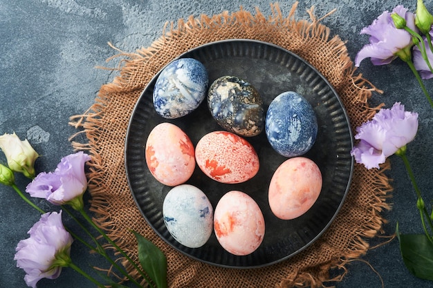 Oeufs de Pâques Oeufs de Pâques teints avec effet pierre de marbre ref et couleur bleue dans un style rustique sur fond de pierre sombre Fond de Pâques Vue de dessus
