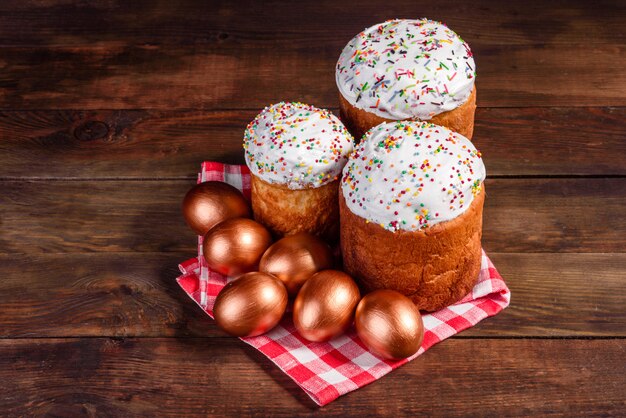 Oeufs de Pâques or et bronze et gâteau de Pâques. Préparation pour les vacances