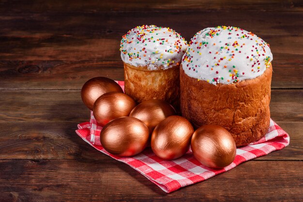 Oeufs de Pâques or et bronze et gâteau de Pâques. Préparation pour les vacances