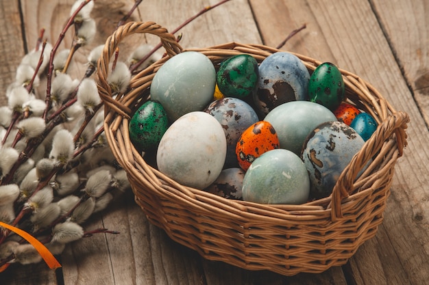 Oeufs de Pâques sur un panier avec des brindilles de saule