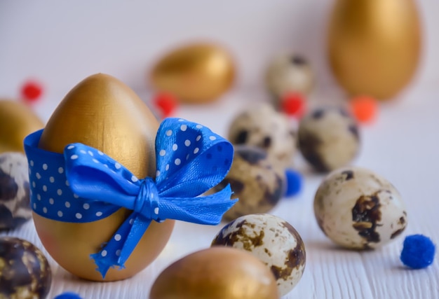 Oeufs de Pâques Pâques poulet et caille or et couleur naturelle sur un fond en bois blanc avec un espace réservé au texte