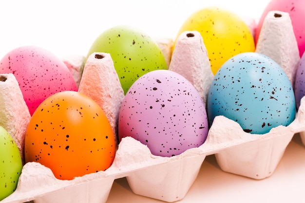 Oeufs de Pâques peints de couleurs vives sur fond blanc.