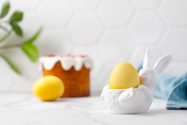 Oeufs de Pâques peints avec du curcuma de couleur jaune dans un lapin en céramique Gâteau de Pâques traditionnel