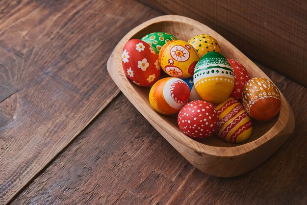 Oeufs de Pâques peints à la main sur fond de bois