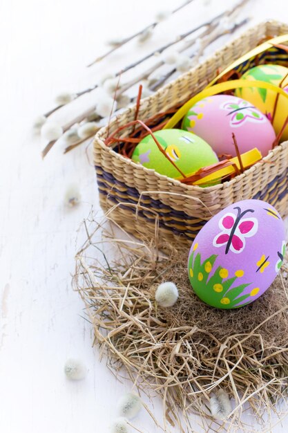 Oeufs de Pâques peints avec des motifs de printemps sur fond blanc, faits à la main.