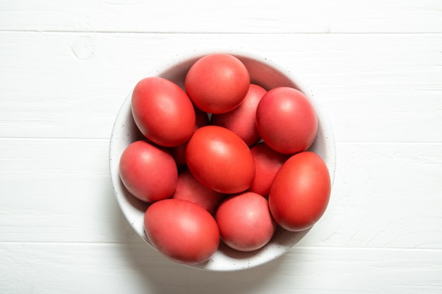 Oeufs de Pâques rouges dans un bol sur la table en bois