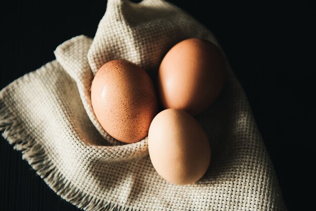 Oeufs de Pâques sur la serviette sur une surface noire. nourriture rustique, rurale, naturelle et saine