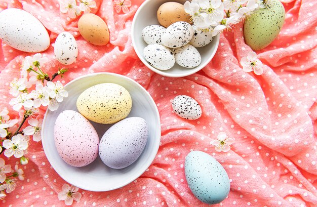 Oeufs de Pâques sur tissu à pois rose avec fleur de cerisier de printemps