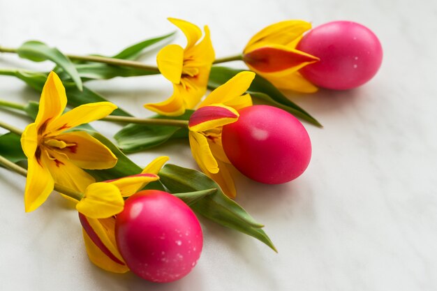 Photo oeufs de pâques avec des tulipes jaunes