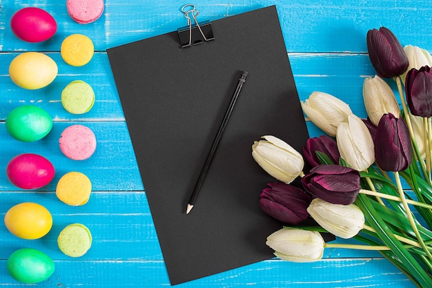 Oeufs de Pâques et tulipes sur des planches de bois bleues