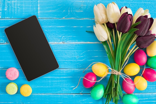 Oeufs de Pâques et tulipes sur des planches de bois bleues