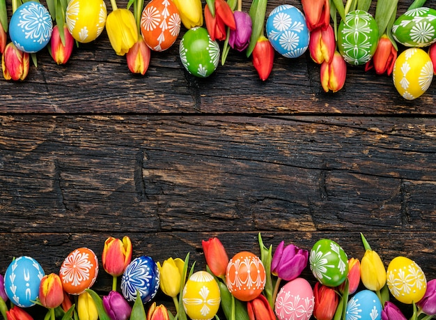 Oeufs de Pâques et tulipes sur planches de bois