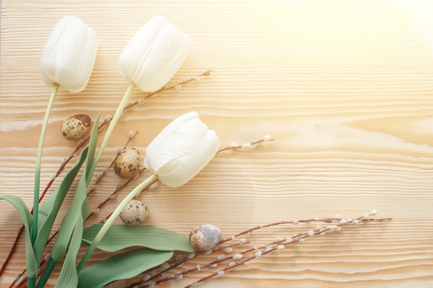 Oeufs de Pâques et les tulipes sur une table en bois. Lumière du matin.