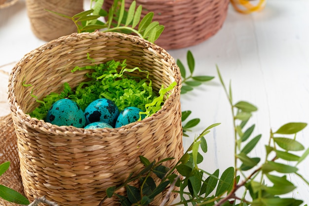 Oeufs peints en bleu dans un nid pour Pâques