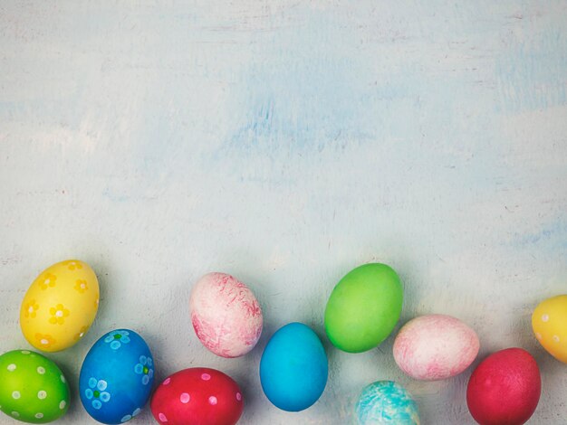 Oeufs peints multicolores sur fond bleu Le concept de place de Pâques pour le texte