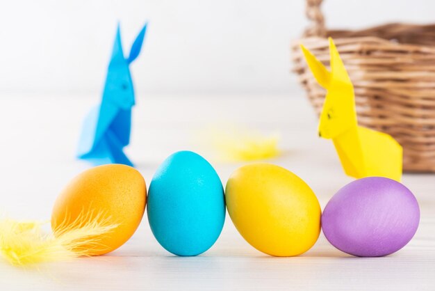 Oeufs peints multicolores de Pâques sur le fond des lapins de papier