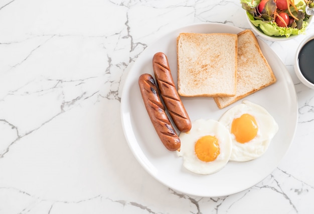 œufs sur le plat avec des saucisses et du pain